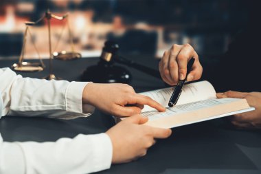 Dava ya da dava açmaya hazırlanan yakın avukat meslektaşları, hukuk fakültesi konsepti için kütüphanede hukuk kitabı okuyup parmakla işaret ediyorlar, hukuki sembollerle süslenmişler. Eşitlik