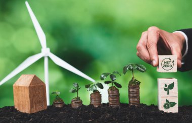 İş adamı ESG sembolü tutuyor. Bozuk para ve rüzgar türbini tohumu ile. Çevre sosyal yönetimi ve CO2 kirliliği emisyonunu azaltmak için sürdürülebilir enerjiye yönelik kurumsal sorumluluk. Değiştir