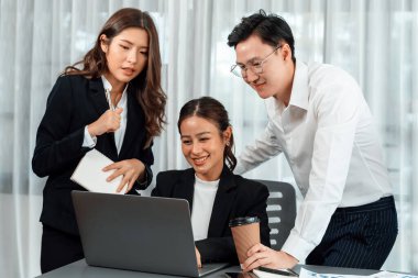 Harmony in office concept as business people analyzing dashboard paper together in workplace. Young colleagues give ideas at manager desk for discussion or strategy planning about project.