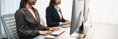 Panorama çağrı merkezi operatör takımı ya da telesales temsilcisi ofis masasında oturan, kulaklık takan ve müşteri desteği sağlayan ya da satış yapan bir müşteriyle sohbet halindedir. Dahi.