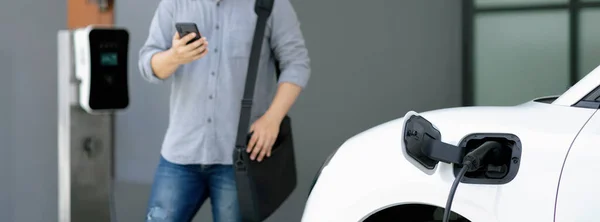 Progressive Asian Man Electric Car Home Charging Station Concept Use — 图库照片