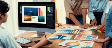 Grafik tasarımcısı, modern dijital stüdyo işyerinde profesyonel grafik ekibiyle benzersiz bir tasarım yaparken bilgisayar dizüstü bilgisayar ve grafik çizim kalemi üzerinde çalışır. Panorama çekimi. İnceleyin