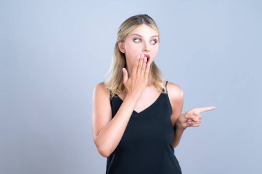 Alluring portrait of beautiful woman with perfect makeup clean skin pointing finger side way in copyspace isolated background. Promotion indicated by hand gesture concept for skincare advertisement.
