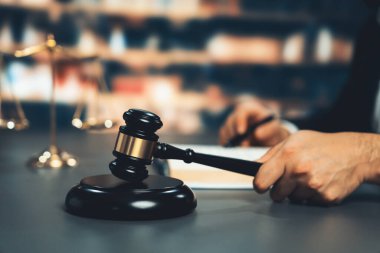 Siyah ahşap tokmağı kavrayıp kütüphanedeki ya da mahkeme salonundaki bulanık hakimin yargı sisteminin hukuk sistemi kavramı olarak çıkardığı sesi bastırmaya odaklanın. Eşitlik