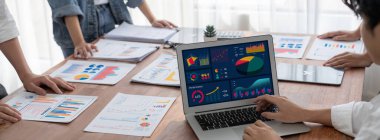 Panorama analist ekibi, FBI Fintech 'i kullanarak dizüstü bilgisayarla mali raporu analiz ediyor. İş adamları iş görüşü için dizüstü bilgisayarda gösterilen kontrol panelini inceliyor. İnceleyin