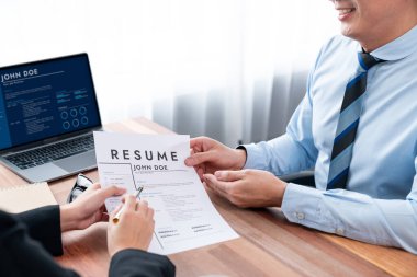 Görüşmeci ve aday arasındaki iş görüşmesi. Asyalı kadın iş başvurusu yapan kişi performansını ve niteliğini dizüstü bilgisayar ve özgeçmişiyle İnsan Kaynakları müdürüne sunar. Sevinçli.