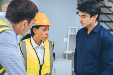 A competent investor investor briefs his engineers on blueprints or construction plans before putting them into action. Concept of investment plans for engineering projects.