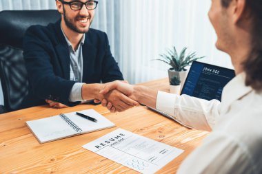 Başarılı bir toplantıdan ya da iş görüşmesinden sonra iki mutlu iş adamı, özgeçmiş belgelerini teslim ederken el sıkışıyor. İnsan Kaynakları müdürü, yeni çalışanı tebrik etmek için iş başvurusunda bulunan kişiye elini uzatıyor. Varlık