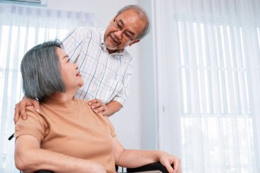 A contented senior couple and their in-home nurse. Elderly female in wheelchair with her young caregiver.