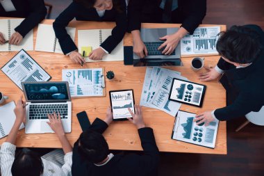Top-view business team of financial data analysis meeting with business intelligence, report paper and dashboard on laptop for marketing strategy. Business people working together in office of harmony