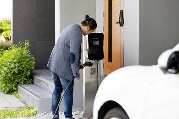 Progressive Asian Man Install Cable Plug His Electric Car Home — Zdjęcie stockowe