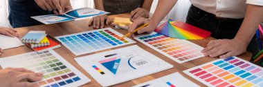 Grafik tasarımcı beyin fırtınası logosu ve grafik sanat yoğun yaratıcı stüdyo atölyesinde. Yaratıcı tasarım için çalışma masasında deney ve beyin fırtınası renk paleti ve desen. Panorama çekimi. İnceleyin