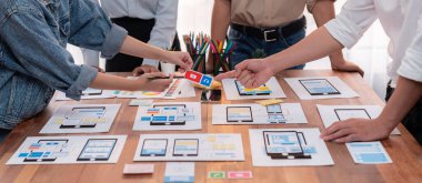 Kağıt kablo arayüzü üzerinde mobil uygulama için UI ve UX tasarımları yapan ön-uç geliştirici ekibin panorama görüntüsü. Kullanıcı dostu UI tasarımı için kullanıcı arayüzü geliştirme ekibi planlama. İnceleyin