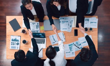 Top-view business team of financial data analysis meeting with business intelligence, report paper and dashboard on laptop for marketing strategy. Business people working together in office of harmony