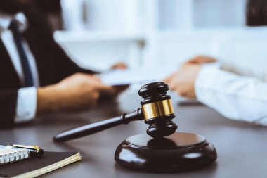 Ahşap tokmağı, avukat meslektaşlarının bulanık arkaplanlarına ya da hukuk bürosundaki işyerlerine yasal belgeler hazırlamaya odaklayın. Adil ve eşit yargılama için adaletin çekici. Eşitlik