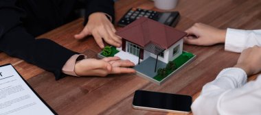 Temsilciyle ev kredisi sözleşmesini gözden geçiriyorum. Mali belgeleri ve vergi oranlarını, mülkiyet sahibi olmak için hesap makinesiyle analiz ediyorum. Yeni ev alımı ve finansman için anahtar imza. Coşkulu.