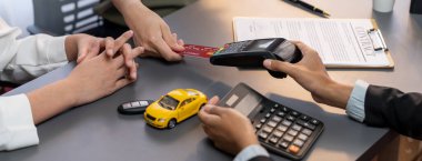 Müşteri, araba satıcısıyla işi bittikten sonra kredi kartıyla elektronik terminalden yeni bir araba alır. Güvenli elektronik dijital ödemeyle düzgün bir araba sahibi. Dahi.