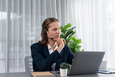 Erkek müşteri hizmetleri operatörü ya da telesales temsilcisi ofiste oturuyor, kulaklık takıyor ve müşteriyle satış desteği ya da kapanış konuşması yapıyor. Çağrı merkezi portresi. Varlık