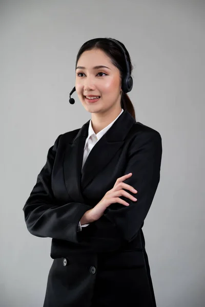 有魅力的亚裔女性呼叫中心操作员面带笑容 在空旷的空间刊登招聘广告 穿着正式西服 头戴可定制的独立背景耳机 很有激情 — 图库照片