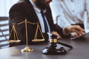 Hukuk bürosundaki masabaşında çalışan avukatın bulanık arka planına odaklan. Gavel, kanun koyucu ve avukatın adil ve eşit karar vermesi için çekiç. Eşitlik