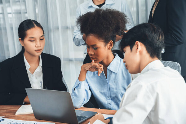 Счастливые бизнесмены работают вместе, обсуждая это в корпоративном офисе. Профессиональная и разнообразная командная работа обсуждают бизнес-план на рабочем столе с ноутбуком. Современный мультикультурный служащий. Конкорд