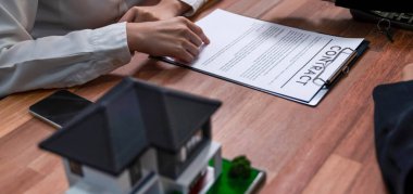 Temsilciyle ev kredisi sözleşmesini gözden geçiriyorum. Mali belgeleri ve vergi oranlarını, mülkiyet sahibi olmak için hesap makinesiyle analiz ediyorum. Yeni ev alımı ve finansman için anahtar imza. Coşkulu.