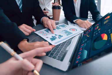 Business team analyze business analytic or business intelligence dashboard on laptop screen show graph and chart with statistic in harmony office. Analyst team meeting researching, planning strategy.