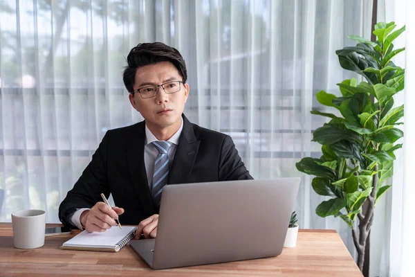 stock image Businessman working on laptop for on office desk workspace. Smart executive researching financial business data or planning strategic business marketing with computer on table. Jubilant