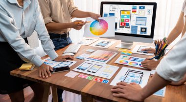 Dizüstü bilgisayar ekranında mobil uygulama için UI ve UX tasarımları tasarlayan ön uç geliştirici ekibin panorama görüntüsü. Kullanıcı dostu UI tasarımı için kullanıcı arayüzü geliştirme ekibi planlama. İnceleyin