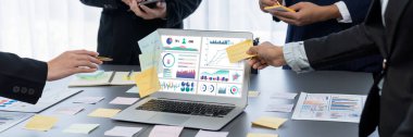 Analizci ekibi yaratıcı ve analitik beyin fırtınası fikri için bilgisayar ekranında BI veri paneli olan yapışkan bir not kullanıyor. Pazarlama stratejisi için finansal veri görselleştirme teknolojisini analiz et. Dahi.