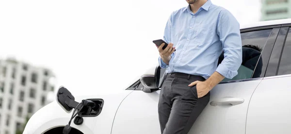 Suit Clad Progressive Businessman Look Cars Battery Status His Phone — Stock Photo, Image