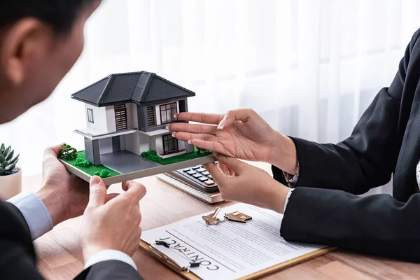 stock image Client and real estate agent review loan contract, discussing term, interest rate, and property ownership. Analyze legal document and thoroughly read agreement before making decision. Jubilant