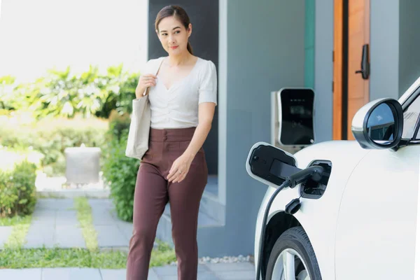 Progressive Asian Woman Electric Car Home Charging Station Concept Use — ストック写真