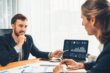 Ofisteki analist ekibi, iş performansını artırmak için bilgisayarında grafik ve çizelge olan BI gösterge panelini kullanarak çalışma alanındaki pazarlama stratejisi için finansal veri analizi yapmakla meşgul. Varlık