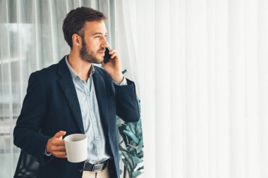 Çalışkan iş adamı, modern ofiste güvenilir bir şekilde müşteriye ikna edici satış çağrıları yapıyor. Ofis çalışanı telefonda konuşuyor ve iş arkadaşlarıyla iş görüşmesi yapıyor. Varlık