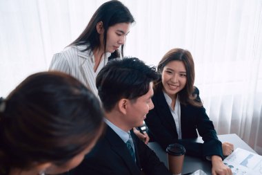 Harmony in office concept as business people analyzing dashboard paper together in workplace. Young colleagues give ideas at manager desk for discussion or strategy planning about project.