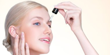 Closeup personable portrait of beautiful woman applying essential oil bottle for skincare product. Cannabis extracted CBD oil dropper for treatment and cannabinoids concept in isolated background.