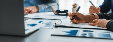 İş zekası ve veri analizi kavramı. İş stratejik planlamasının pazarlama göstergesi olarak kağıt üzerinde finansal veri analizi üzerinde çalışan bir grup analist. İçgörü