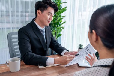 Görüşmeci ve aday arasındaki iş görüşmesi. İK müdürü aday niteliklerini ve özgeçmişli iş başvurusunu soruyor. Başvuru sahibinin işi. Sevinçli.