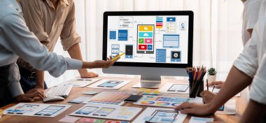 Dizüstü bilgisayar ekranında mobil uygulama için UI ve UX tasarımları tasarlayan ön uç geliştirici ekibin panorama görüntüsü. Kullanıcı dostu UI tasarımı için kullanıcı arayüzü geliştirme ekibi planlama. İnceleyin
