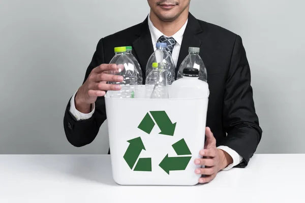 ビジネスマンは 隔離された背景にプラスチックボトルで満たされたごみ箱を保持します 緑の環境とコミュニティのための企業責任 廃棄物分離と管理の概念 Alter — ストック写真