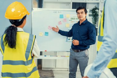A team of investor and competent engineers brainstorming on the whiteboard to find new ideas and making plans. The idea of a team gather ideas together.