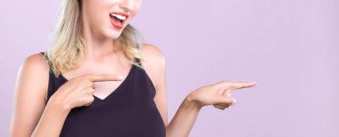 Closeup Alluring beautiful perfect makeup clean skin woman portrait pointing finger side way in copyspace isolated background. Promotion indicated by hand gesture concept for skincare advertisement.