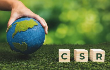 Kâğıt küre ve CSR sembolü küpüyle el ele tutuşan bir iş adamı. CO2 emisyon politikası olmayan çevre dostu yeşil ve etik iş şirketi. Yeşil toplumdan sorumlu kurumsal toplum. Değiştir