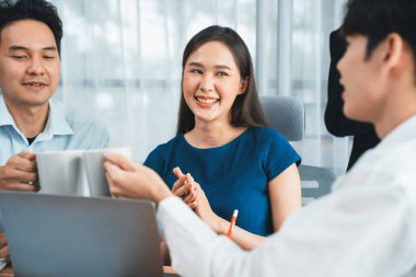 Profesyonel Asyalı çalışanlar, şirket ofisinde takım olarak çalışarak iş planları ve bilgisayarla başarılı olmak için verileri tartışırlar. Modern ofis çalışanı takım çalışması konsepti. Uyum