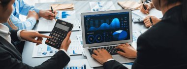 İş zekası ve veri analizi kavramı. Analizci ekibi laptop ekranında finansal veri analizi üzerinde çalışıyor. Etkili iş stratejik planlama için pazarlama göstergesi olarak. İçgörü