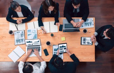 Top-view business team of financial data analysis meeting with business intelligence, report paper and dashboard on laptop for marketing strategy. Business people working together in office of harmony