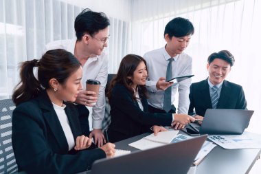 Harmony in office concept as business people analyzing dashboard paper together in workplace. Young colleagues give ideas at manager desk for discussion or strategy planning about project.