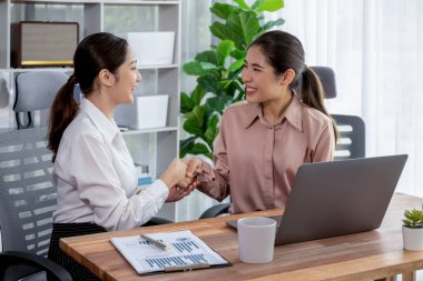 Modern ofis çalışma alanında iş birliği yapan iki genç ofis çalışanı, modern ofis çalışanı olarak profesyonelliklerini sergileyerek, dizüstü bilgisayarda tartışıyorlar ve birlikte çalışıyorlar. Coşkulu.