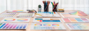 Grafik tasarım konsepti için çalışma masasının üzerine düzgünce düzenlenmiş çeşitli renk paleti fikir kağıtlarının panorama çekimi. Benzersiz dijital sanat tasarımı için renk örnekleri ve seçim. İnceleyin